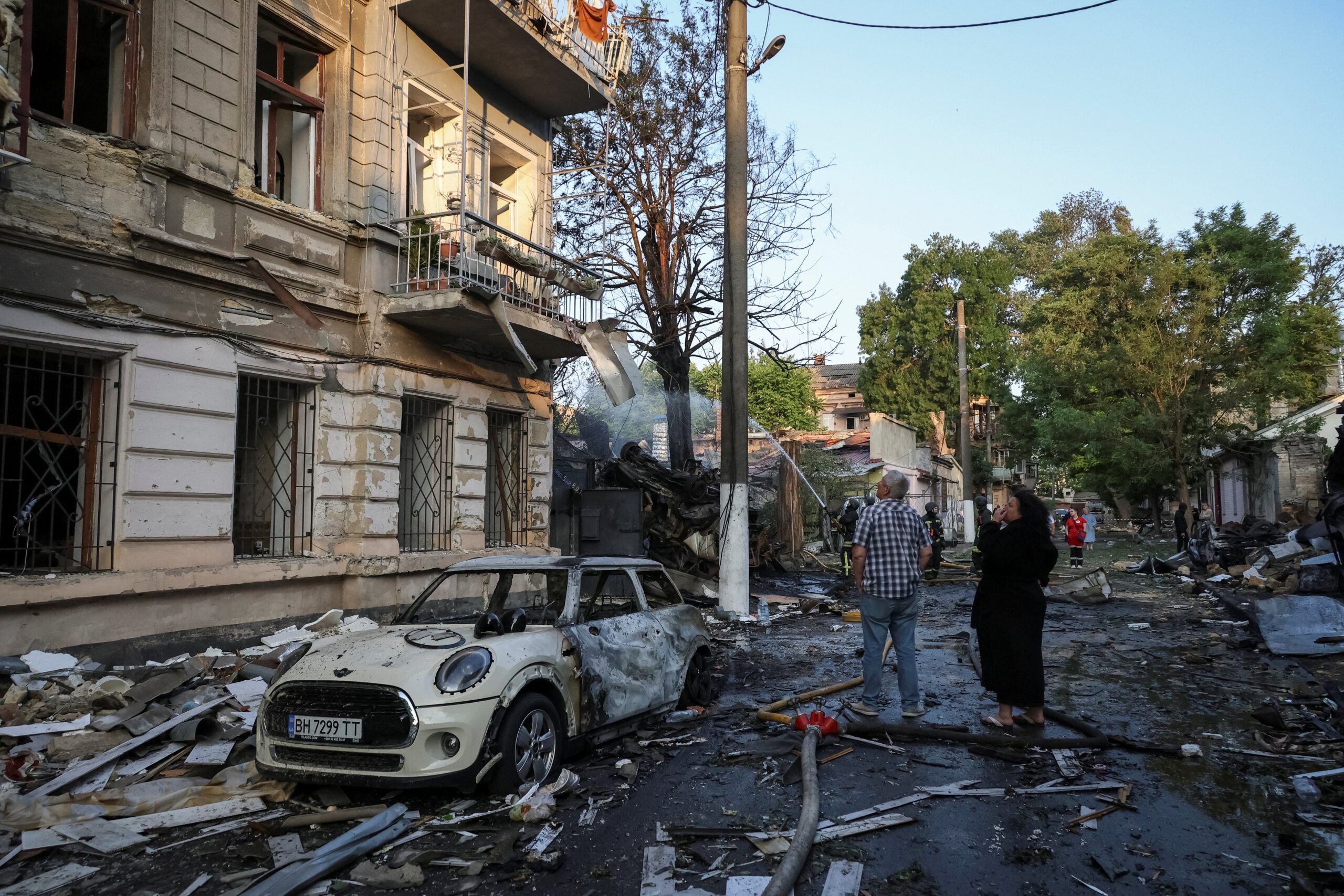 Residents stand at the site of the apartment building hit by a Russian drone strike, amid Russia's attack on Ukraine, in Odesa
