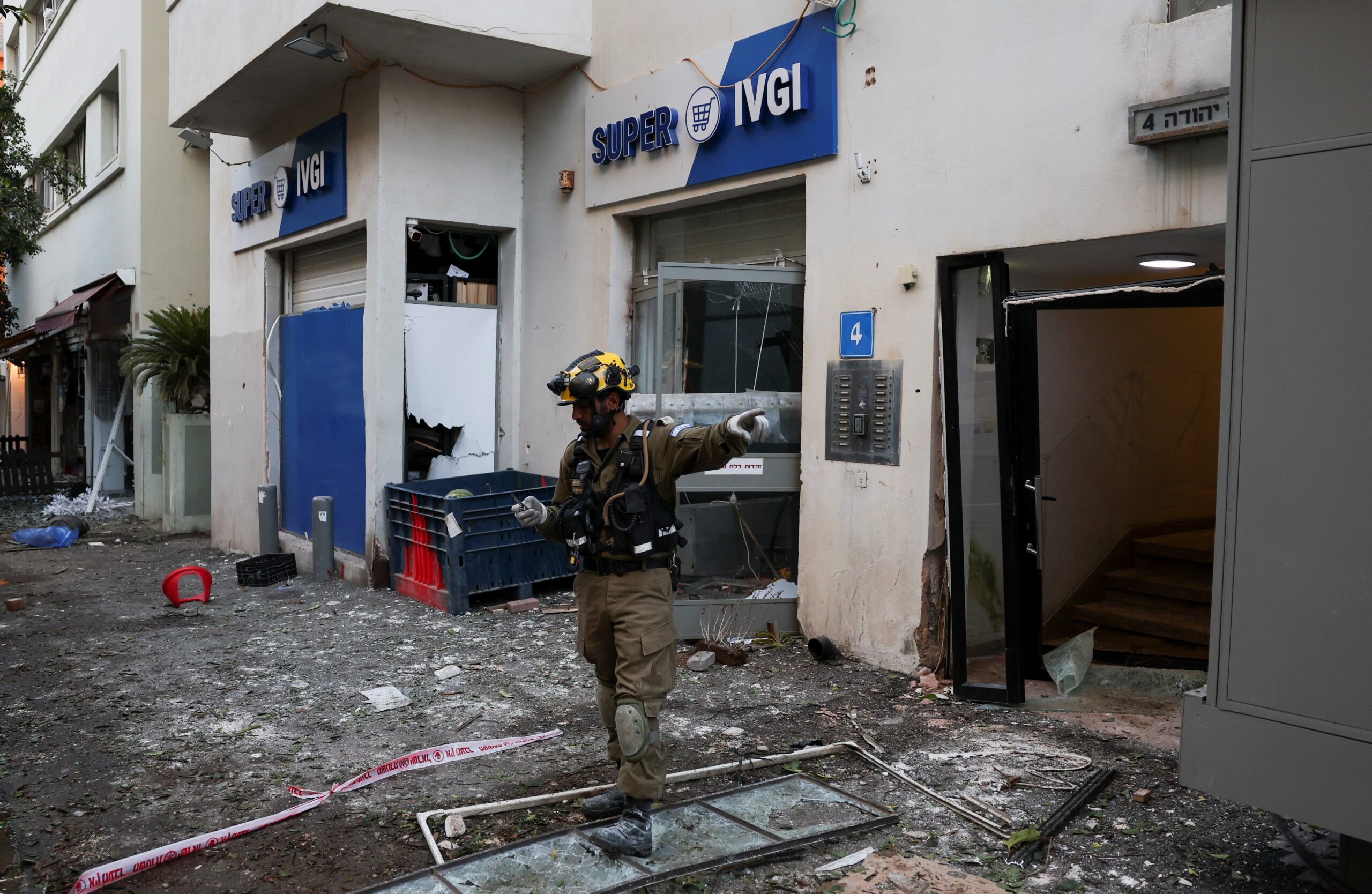 A rescuer gestures as he works at an impact site after missiles were launched from Iran to Israel in Tel Aviv