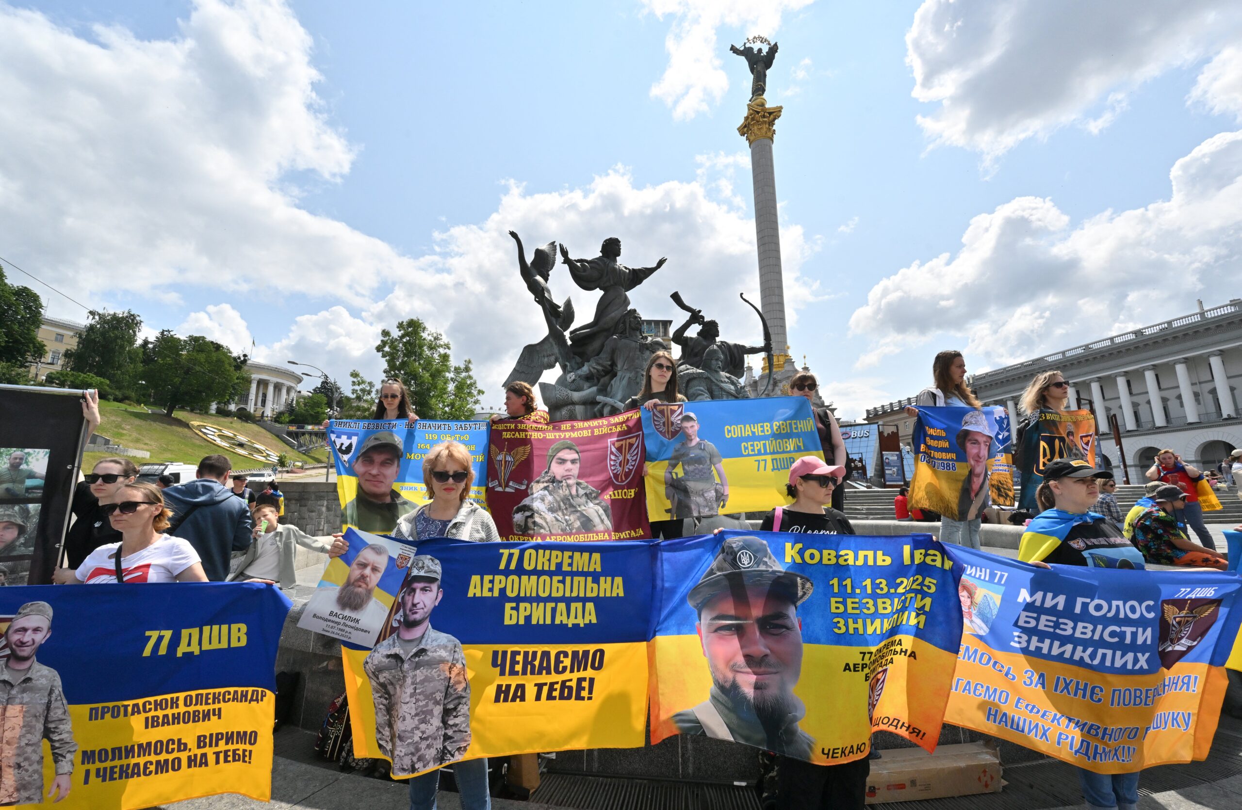 Kin of Ukrainian prisoners of war hold portraits of them during a rally