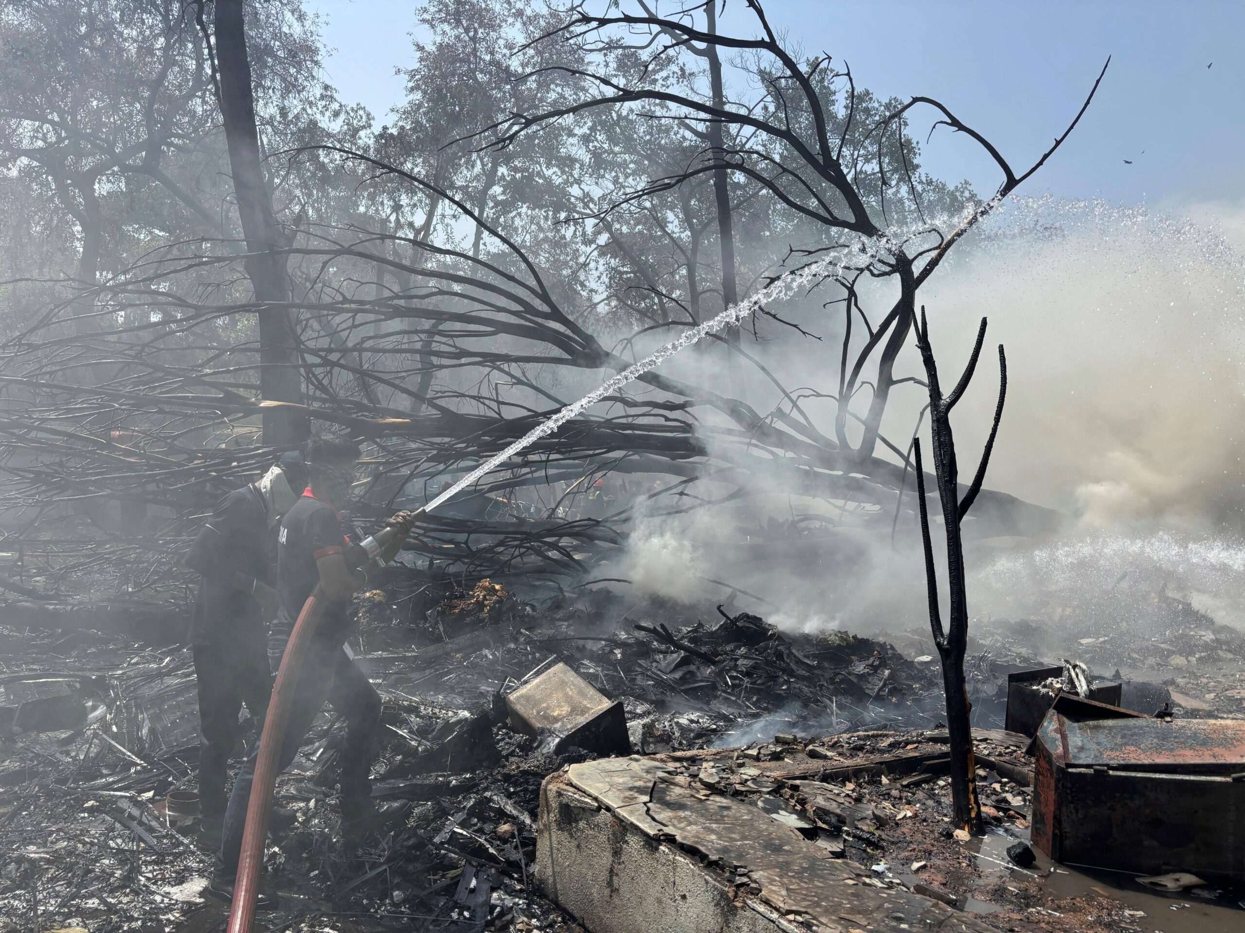 Firefighters work at the site of the crash scene near the airport