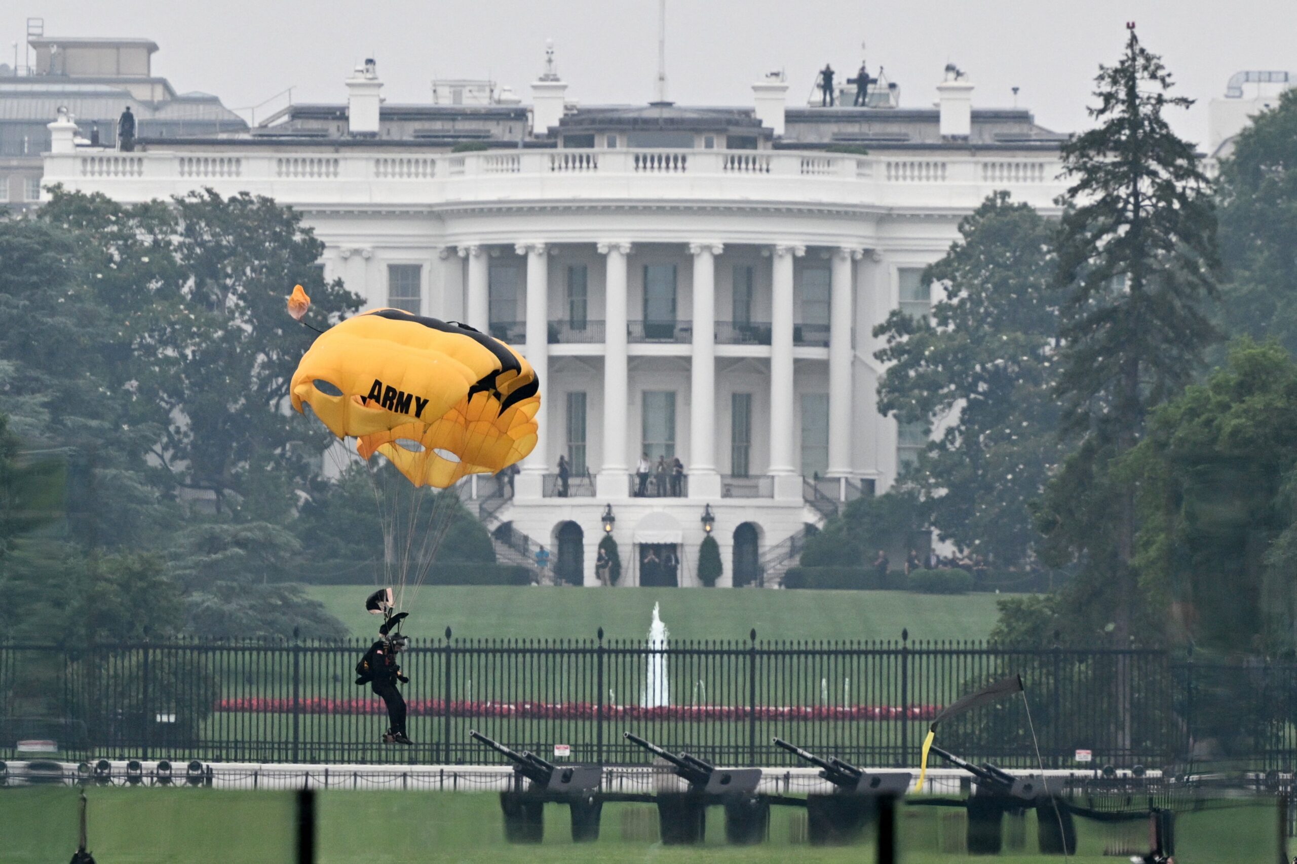 A member of the Golden Knights, the US Army's parachute demonstration and competition team, lands in front of the White House