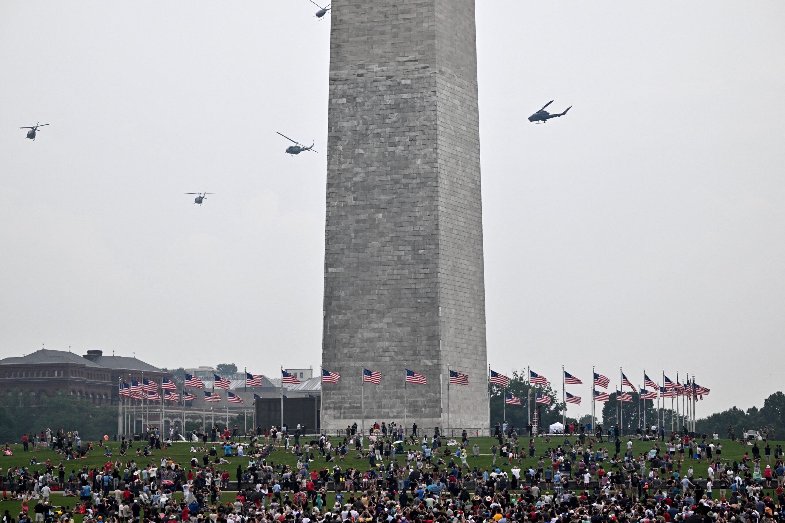 Helicopters are seen near the base of the Washington Monument
