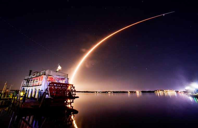 A SpaceX Falcon 9 rocket lifts off from Cape Canaveral Space Force Station, Fla. Saturday, Oct. 21, 2023. The rocket is carrying 23 Starlink satellites. The launch is viewed from the Cocoa Village Marina in Cocoa, Fla. with the Indian River Queen in the foreground, and appears to be going over Jupiter in the sky. (Malcolm Denemark/Florida Today via AP)