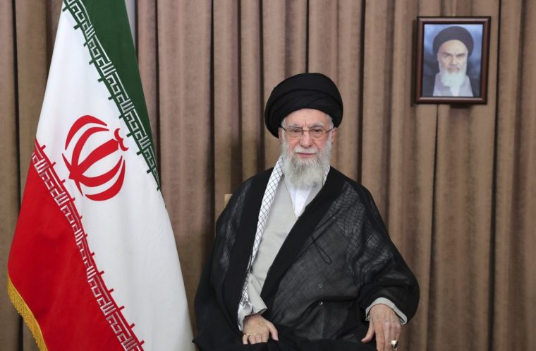This photo released by an official website of the office of the Iranian supreme leader, shows Supreme Leader Ayatollah Ali Khamenei in a televised speech, under a portrait of the late revolutionary founder Ayatollah Khomeini, Friday, June 13, 2025. (Office of the Iranian Supreme Leader via AP)