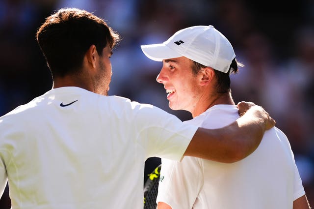 Carlos Alcaraz puts an arm around Oliver Tarvet
