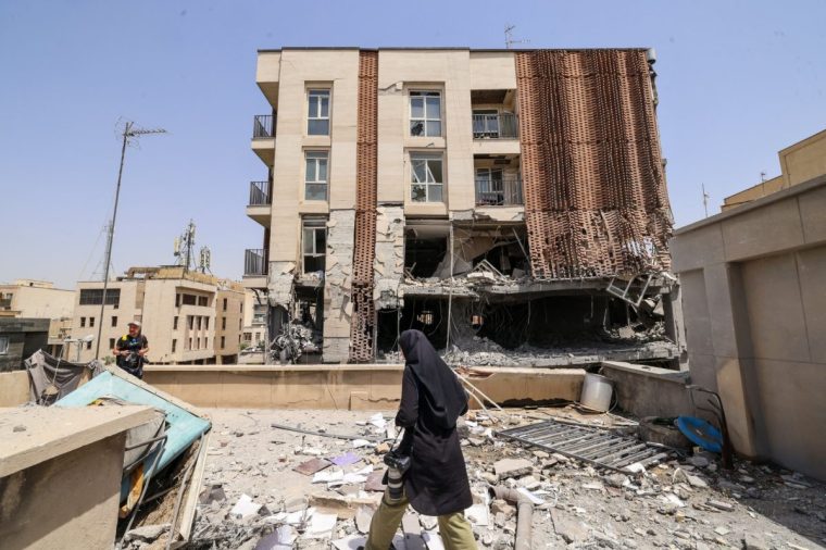 Journalists work on the roof of a residential building that was hit in an Israeli strike, in Tehran, on June 25, 2025. A fragile ceasefire in the Iran-Israel war appeared to be holding on June 25, after 12 days of strikes that saw Israel and the United States pummel the Islamic republic's nuclear facilities. (Photo by ATTA KENARE / AFP) (Photo by ATTA KENARE/AFP via Getty Images)