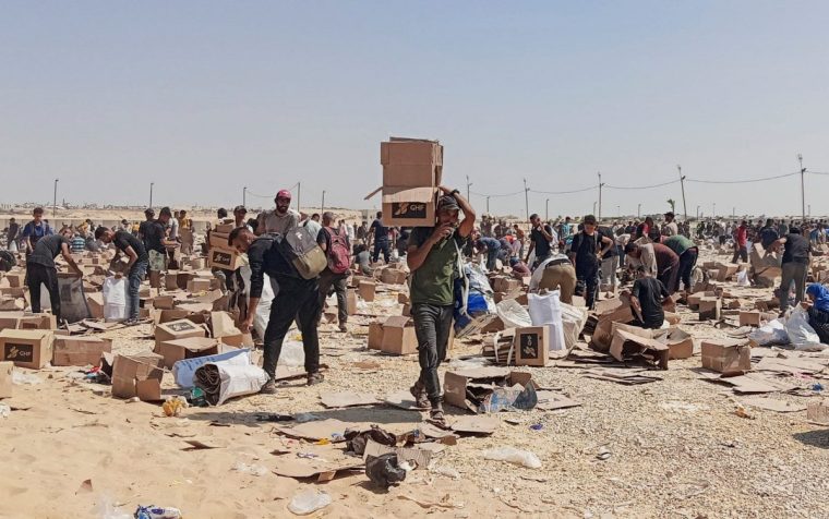 FILE PHOTO: Palestinians collect what remains of relief supplies from the distribution center of the U.S.-backed Gaza Humanitarian Foundation, in Rafah, in the southern Gaza Strip, June 5, 2025. REUTERS/Stringer/File Photo
