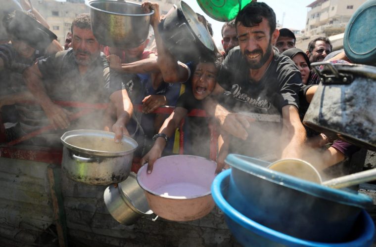 Palestinians wait to receive food from a charity kitchen, amid a hunger crisis, in Gaza City, July 23, 2025. REUTERS/Mahmoud Issa