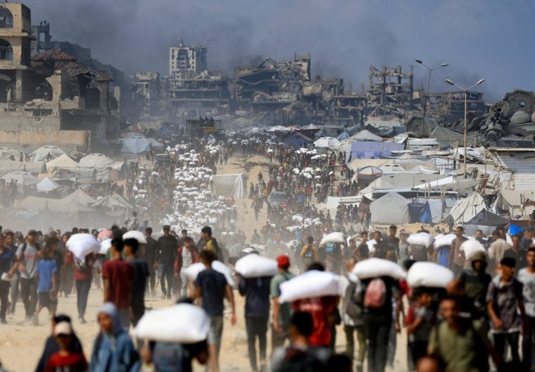 FILE PHOTO: Palestinians gather as they carry aid supplies that entered Gaza through Israel, amid a hunger crisis, in Beit Lahia in the northern Gaza Strip July 20, 2025. REUTERS/Dawoud Abu Alkas/File Photo