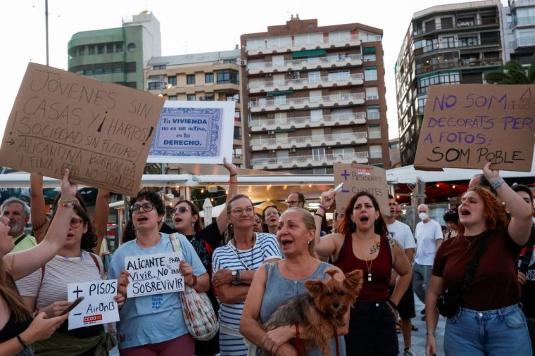 Demonstrators hold placards as they protest against mass tourism in Alicante, Spain, July 25, 2025. REUTERS/Eva Manez