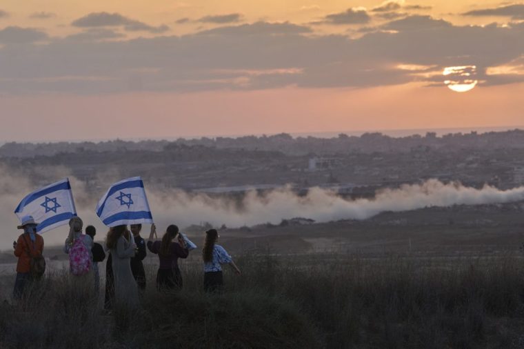 Israeli right-wing activists watch the northern Gaza Strip during a rally calling for the re-establishment of Jewish settlements in the Gaza Strip, near the border in southern Israel, Wednesday, July 30, 2025. (AP Photo/Ohad Zwigenberg)
