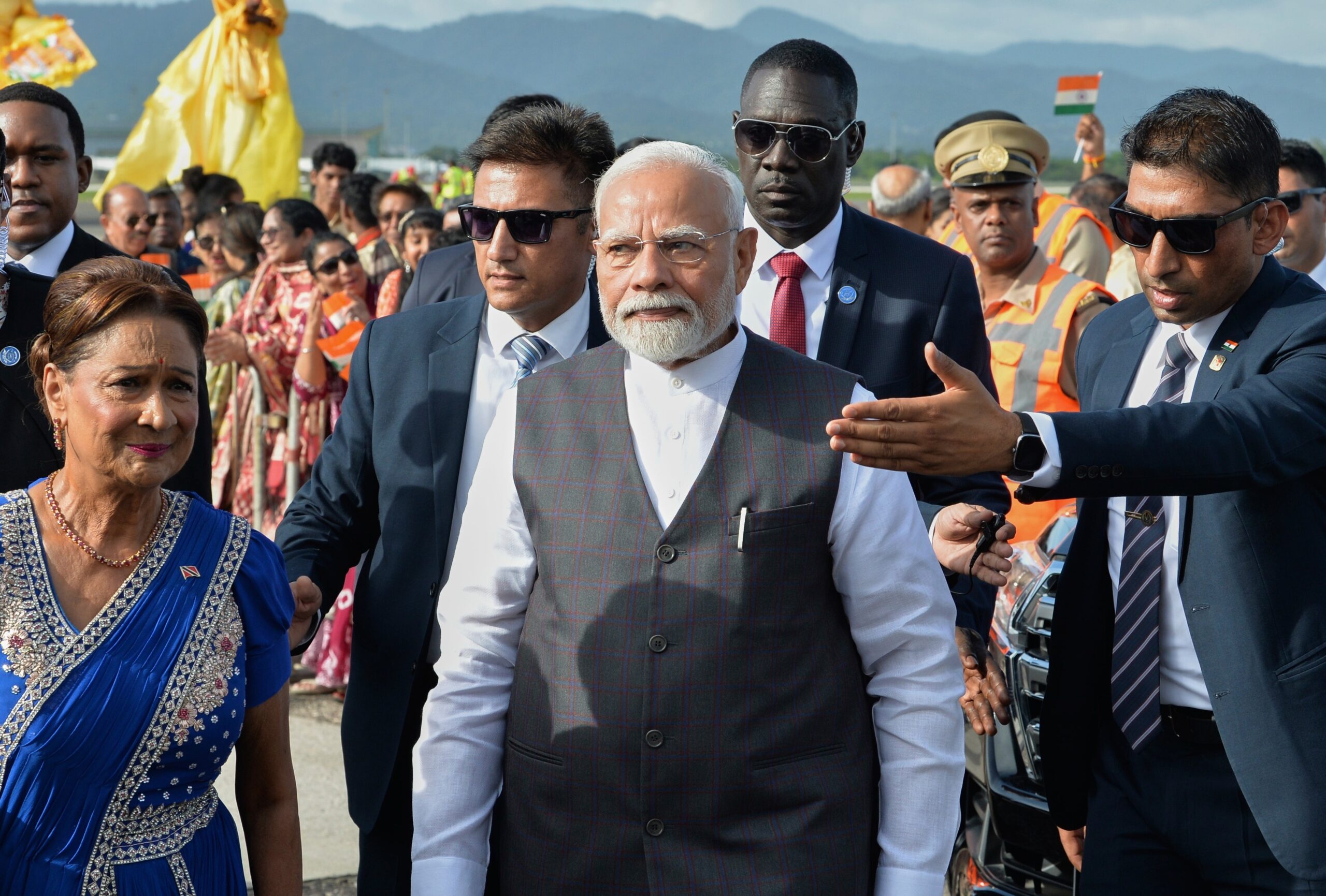 File. Narendra Modi, center, walks with Trinidad and Tobago prime minister Kamla Persad-Bissessar upon his arrival in Piarco on 3 July 2025