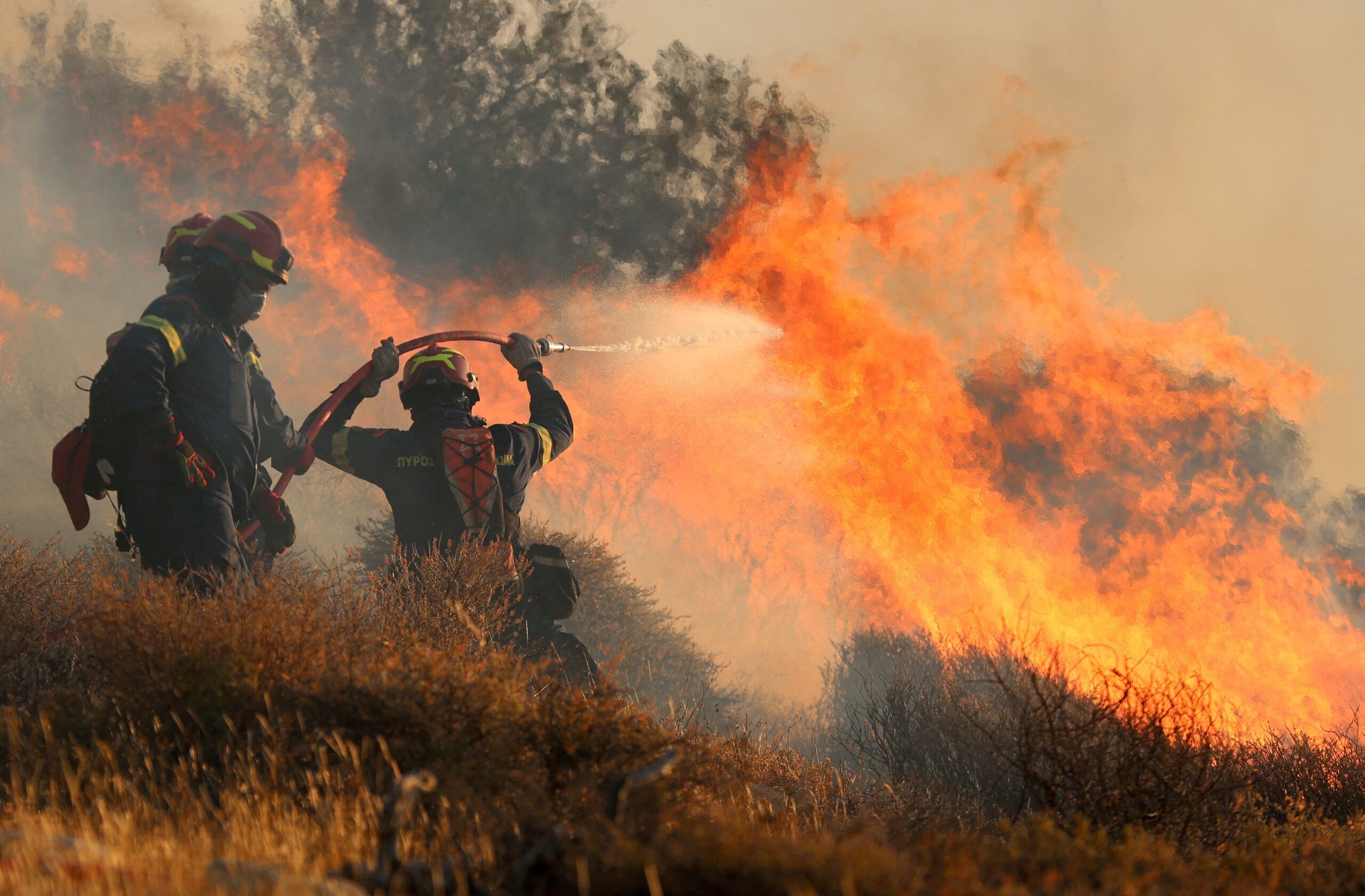 Firefighters try to extinguish a wildfire near Ierapetra, on the island of Crete