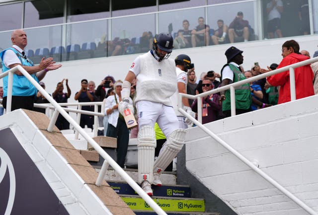 England’s Chris Woakes, with his arm in a sling, heads out to bat on day five