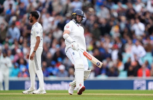 Chris Woakes, with his arm in a sling, runs between the stumps