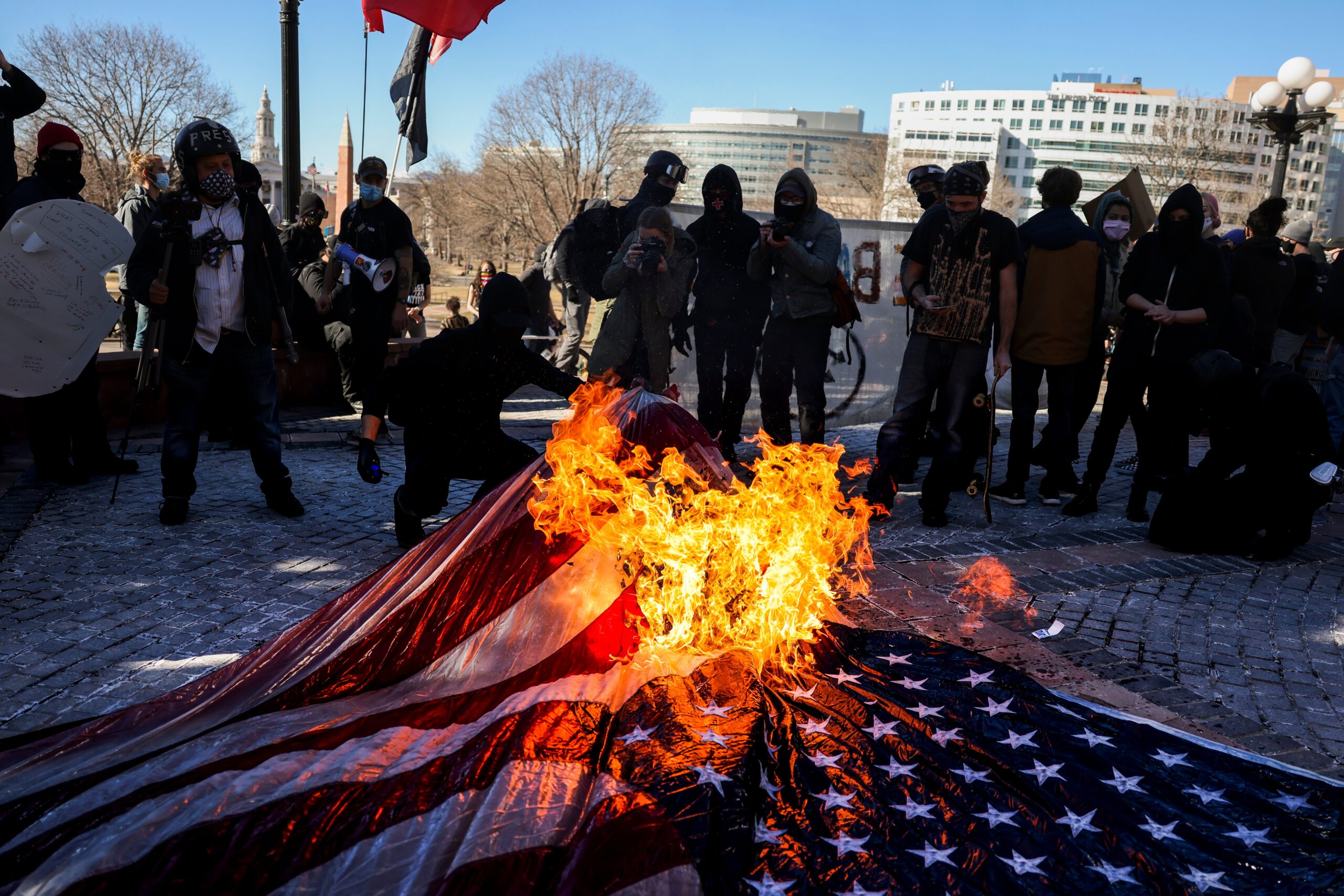 Protesters burn an American flag at a demonstration in Denver, Colo.