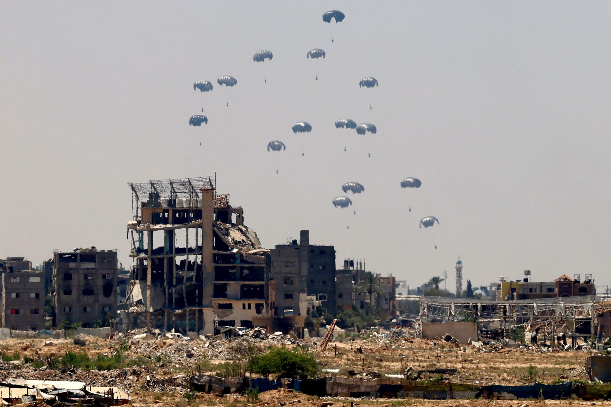Aid pallets are parachuted after being dropped from a military plane over Nuseirat in the central Gaza Strip during an airdrop mission above the Israel-besieged Palestinian territory on August 4, 2025.