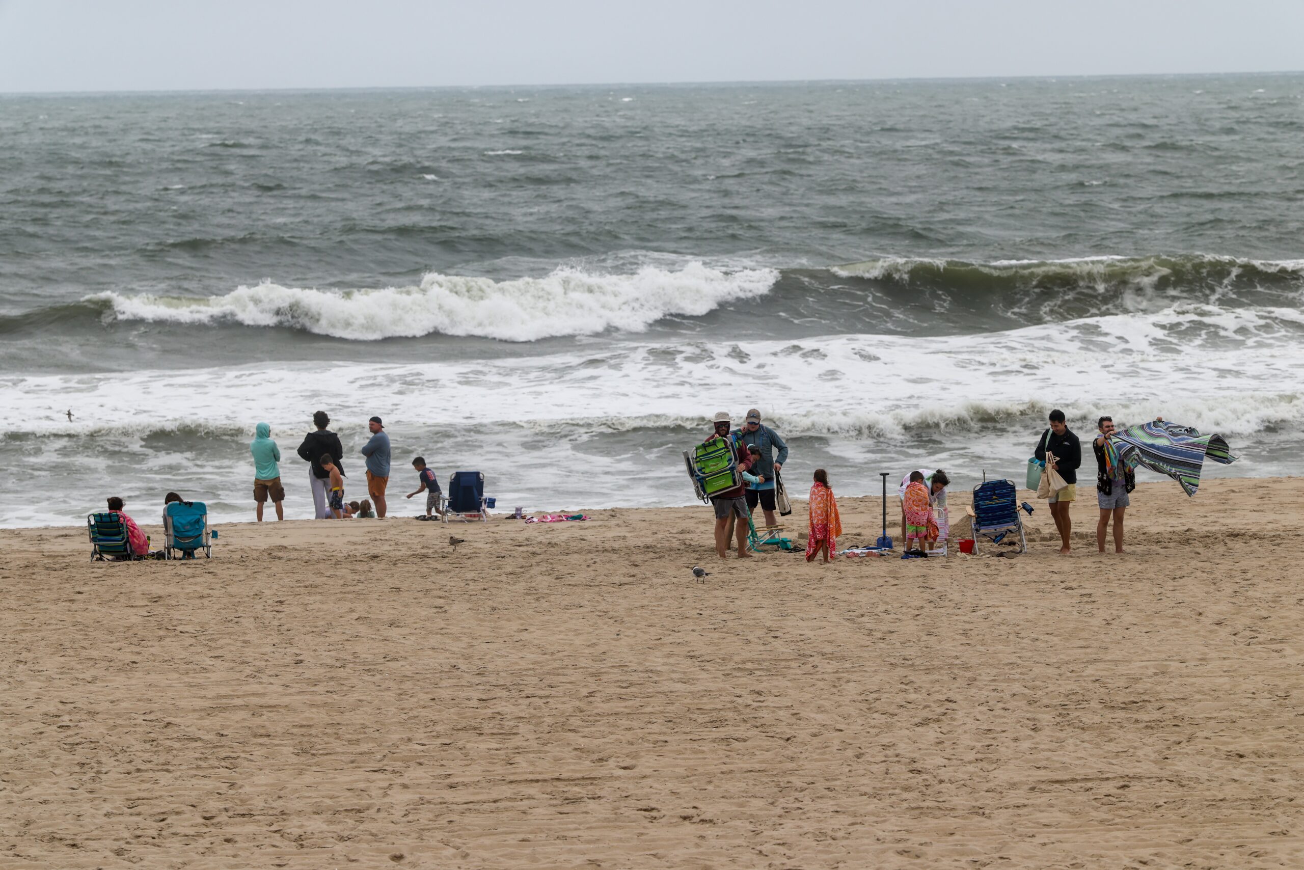 Despite no swimming being allowed, people still showed up at the beach to stand at the water's edge and watch the waves