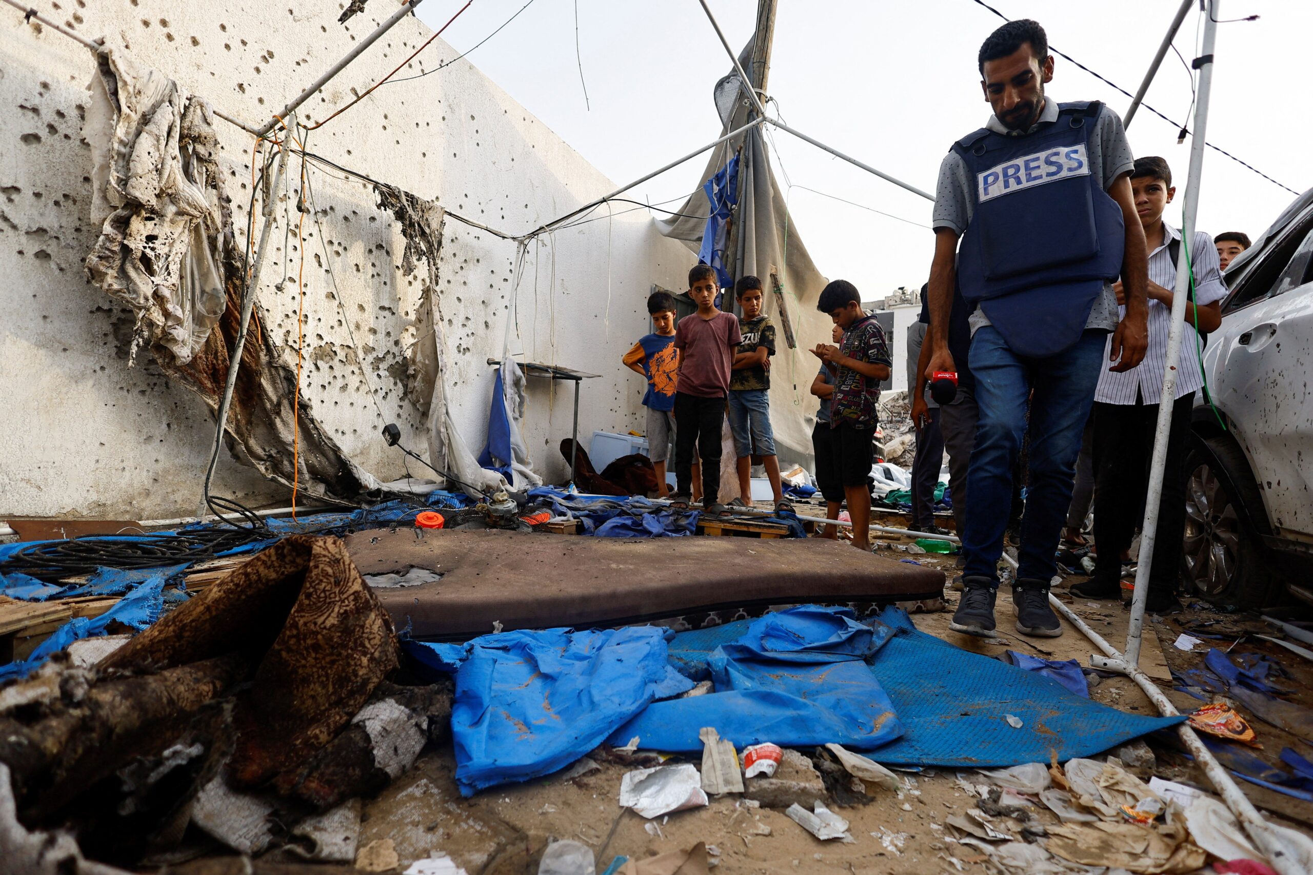 A member of the media inspects the damage at the site of an Israeli strike on a tent near Shifa Hospital where Al Jazeera journalists Anas Al Sharif, Mohammed Qreiqeh, Ibrahim Zaher, and Mohammed Noufal were killed