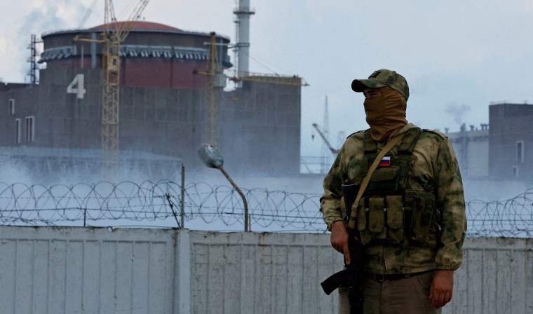 FILE PHOTO: A serviceman with a Russian flag on his uniform stands guard near the Zaporizhzhia Nuclear Power Plant in the course of Ukraine-Russia conflict outside the Russian-controlled city of Enerhodar in the Zaporizhzhia region, Ukraine August 4, 2022. REUTERS/Alexander Ermochenko//File Photo