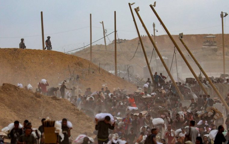 Palestinians carry aid supplies which they received from the U.S.-backed Gaza Humanitarian Foundation (GHF), in the central Gaza Strip, August 1, 2025. REUTERS/Stringer