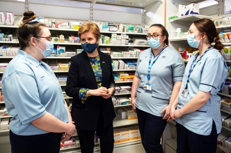 AIRDRIE, SCOTLAND - MARCH 7: Scotland's First Minister Nicola Sturgeon (2nd,L) speaks with trainee pharmacy staff members at Monklands University Hospital, as part of the launch of the Scottish Apprenticeship Week, on March 7, 2022 in Airdrie, Lanarkshire, Scotland. (Photo by Andy Buchanan/WPA Pool/Getty Images)