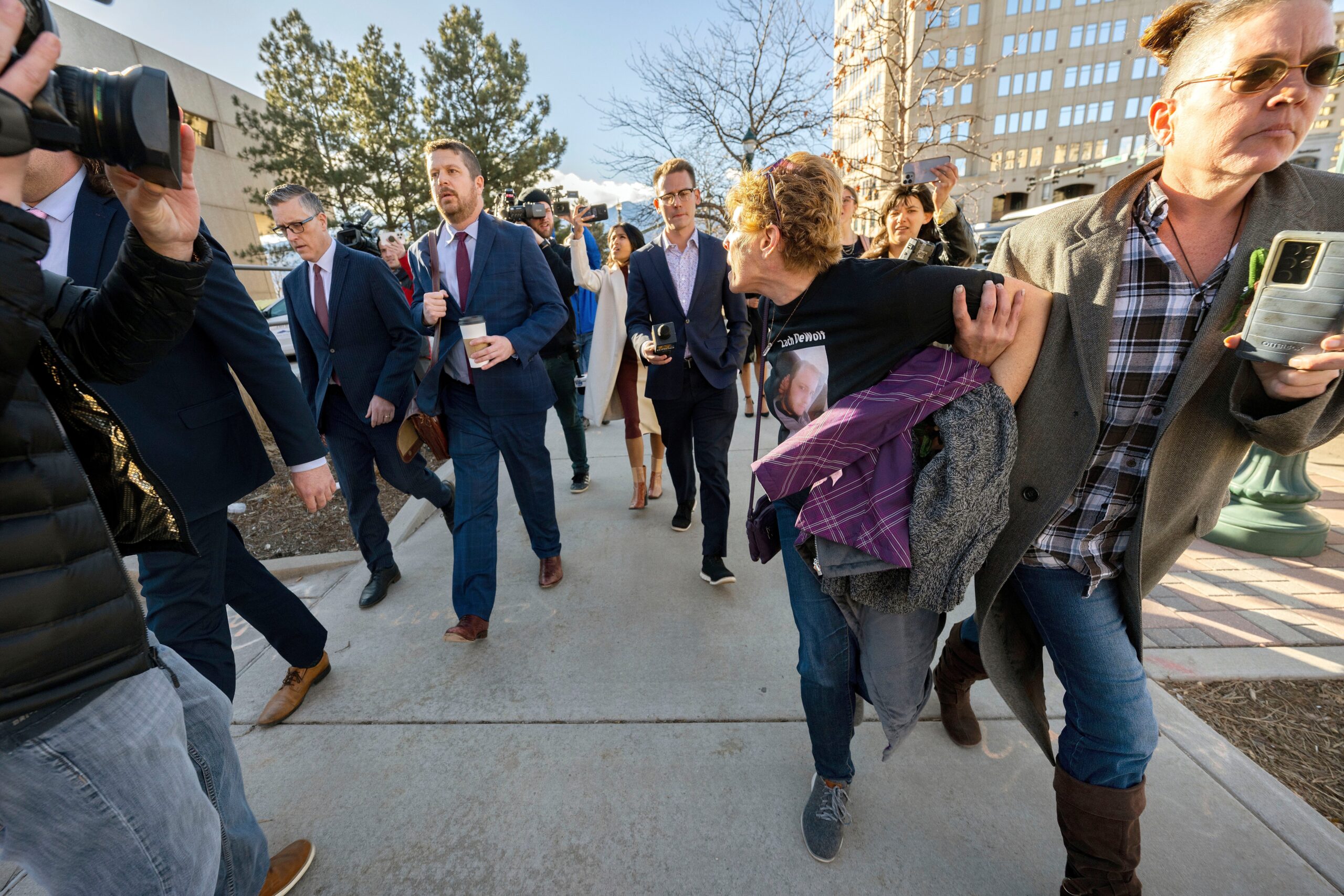 Chrystina Page, right, holds back Heather De Wolf, as she yells at Jon Hallford, left, the owner of Back to Nature Funeral Home, as he leaves with his lawyers following a preliminary hearing, Thursday, Feb. 8, 2024, outside the El Paso County Judicial Building in Colorado Springs, Colo. (Christian Murdock/The Gazette via AP, File)