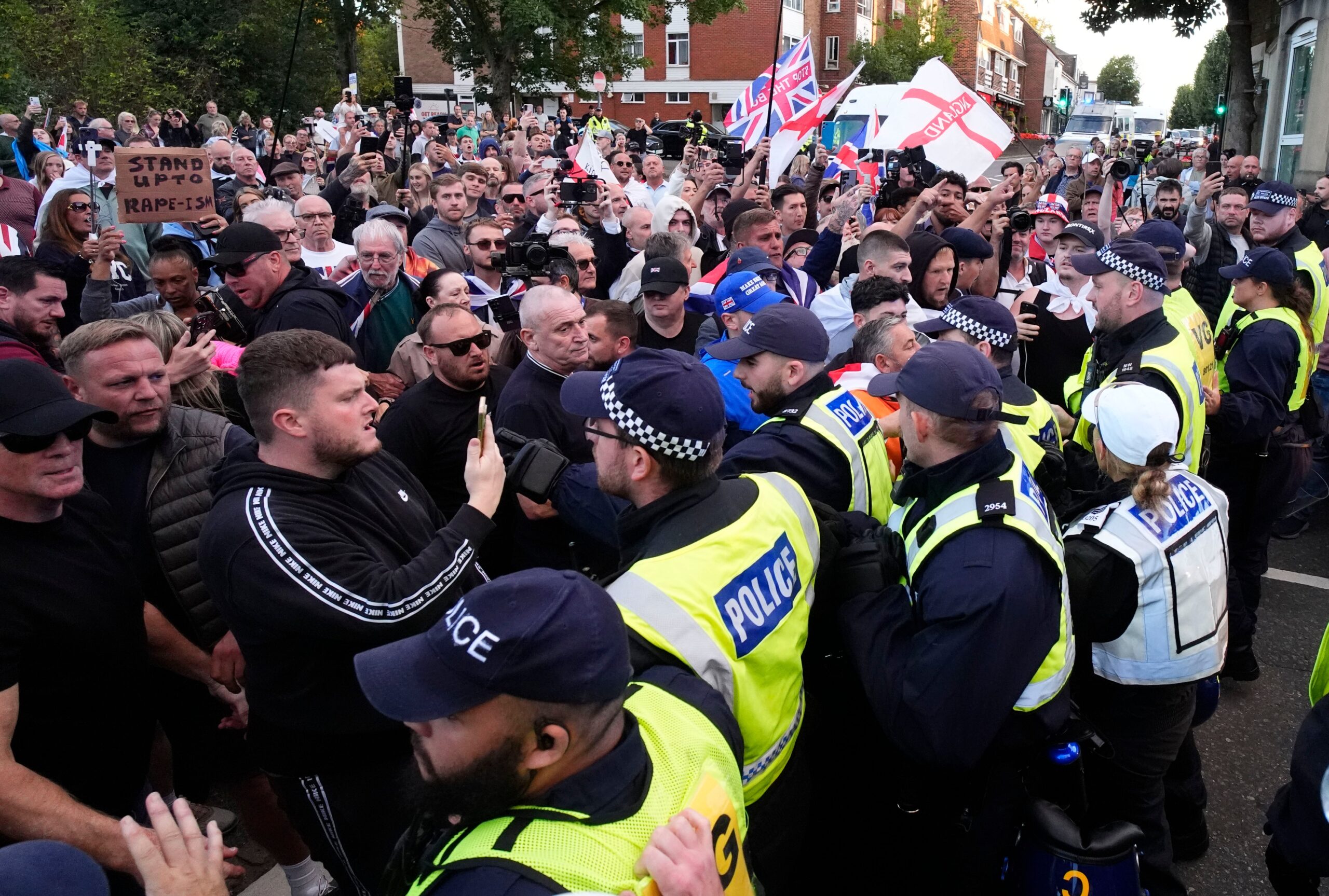 Demonstrators protest to stop a police van leaving after a protester was detained by police