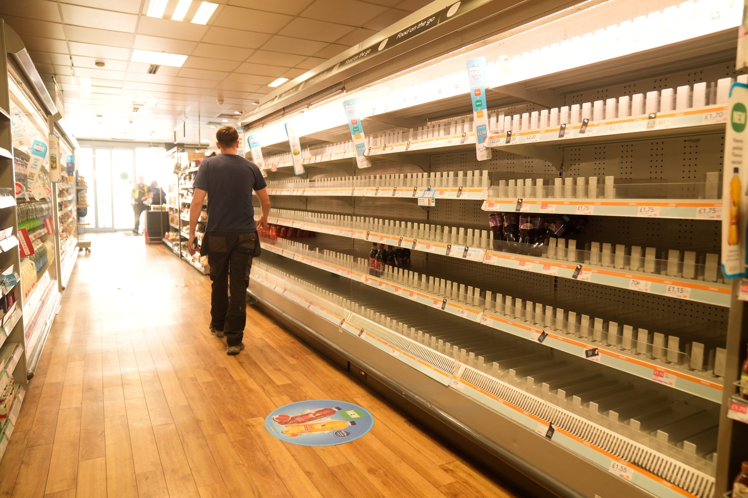 A man walks past empty shelves in a branch of the Co-op in Manchester following the major cyber attack