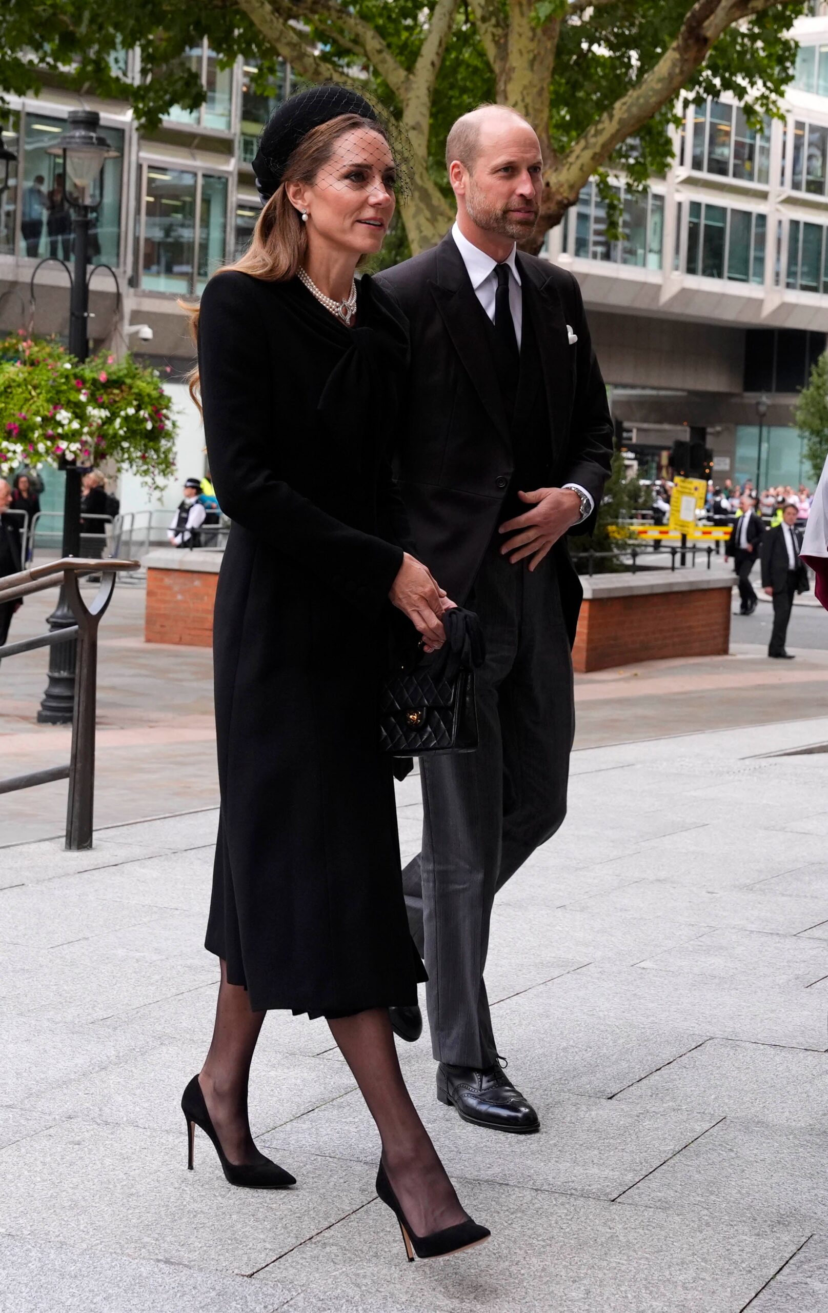 William had a white handkerchief tucked in his top pocket, while Kate wore a black hat with a large bow at the back and netting detail at the front