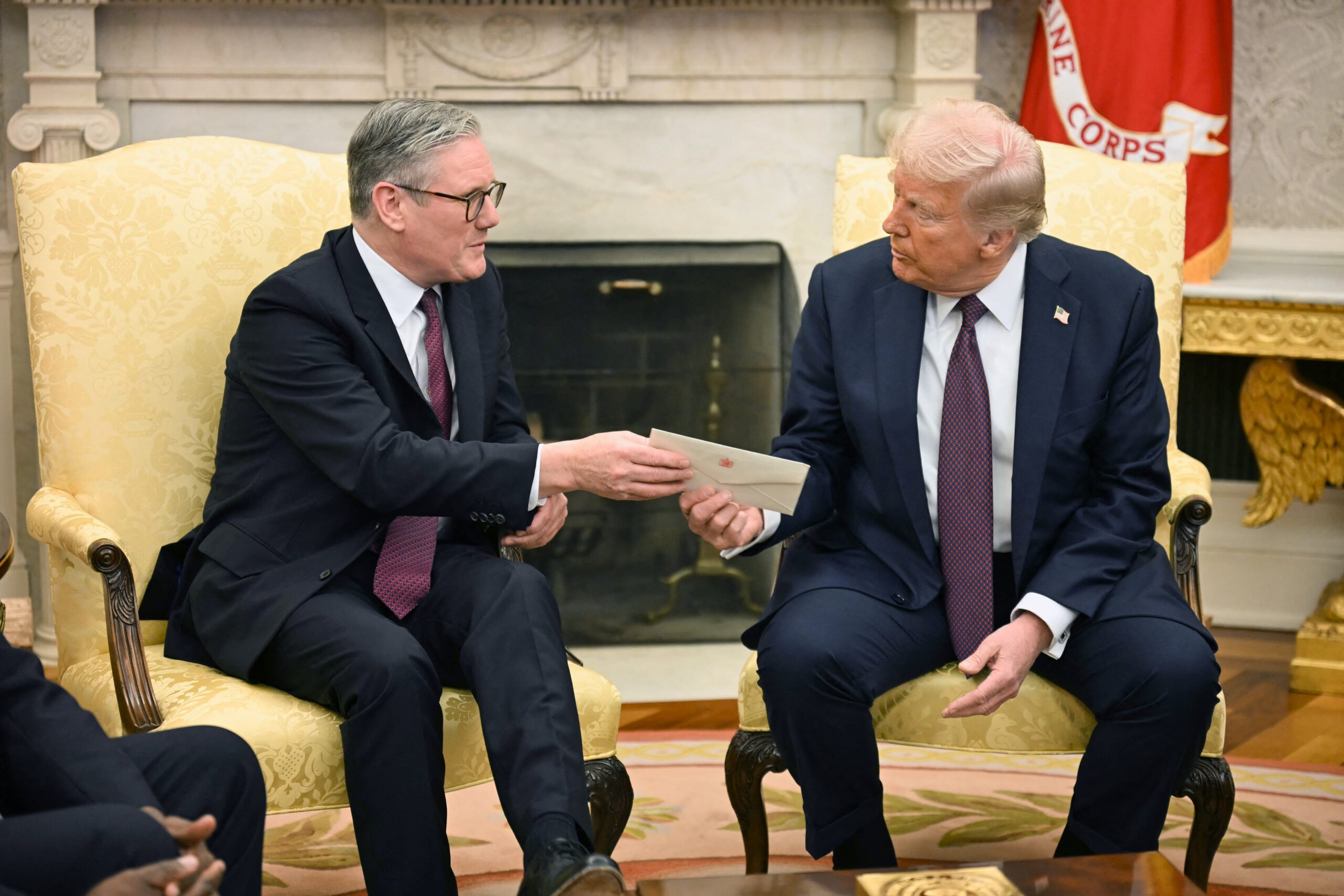 Keir Starmer hands US President Donald Trump a letter from King Charles III during a meeting in the Oval Office of the White House in Washington, DC, on February 27, 2025