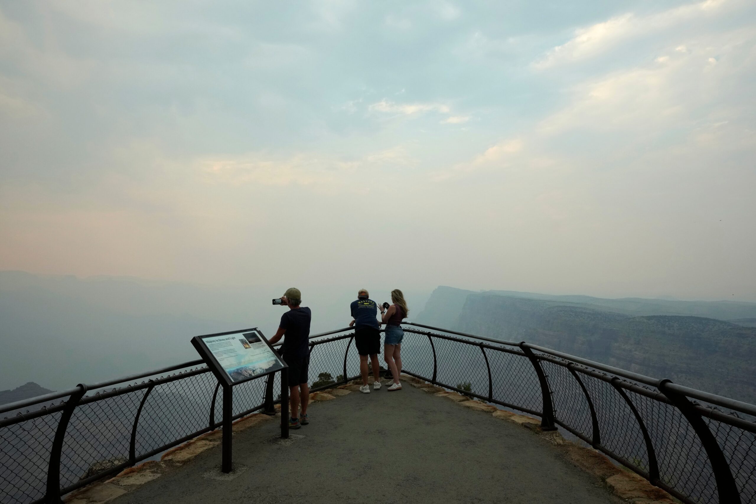 Smoke from the Dragon Bravo Fire moves over the Grand Canyon from the North Rim blocking the view for tourists at the Desert View overlook on 14 July