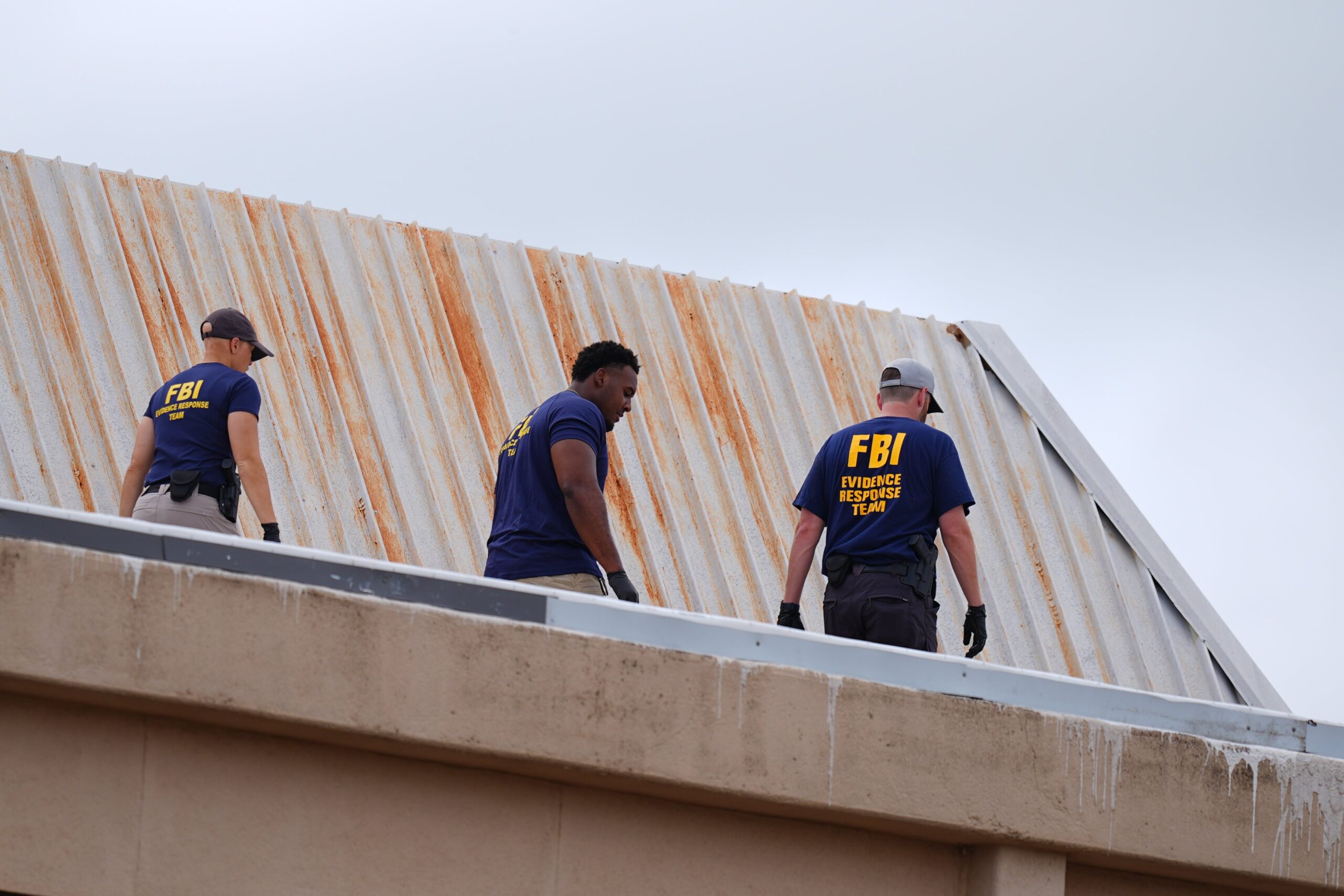 FBI agents inspect the roof of an apartment building near the scene of the shooting