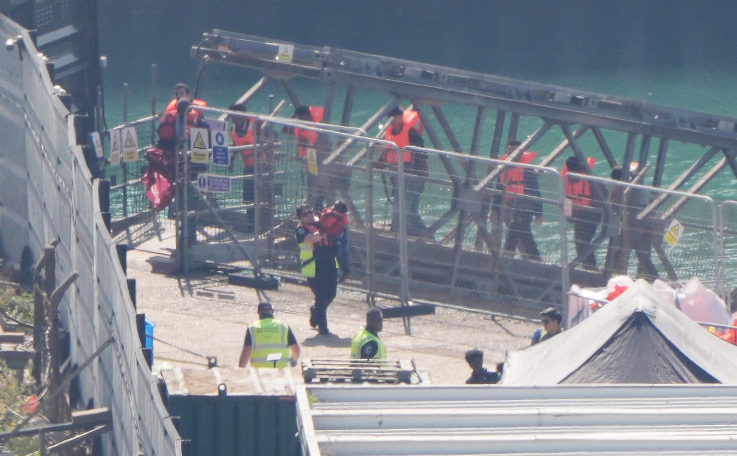 A group of people thought to be migrants are brought in to the Border Force compound in Dover, Kent in July