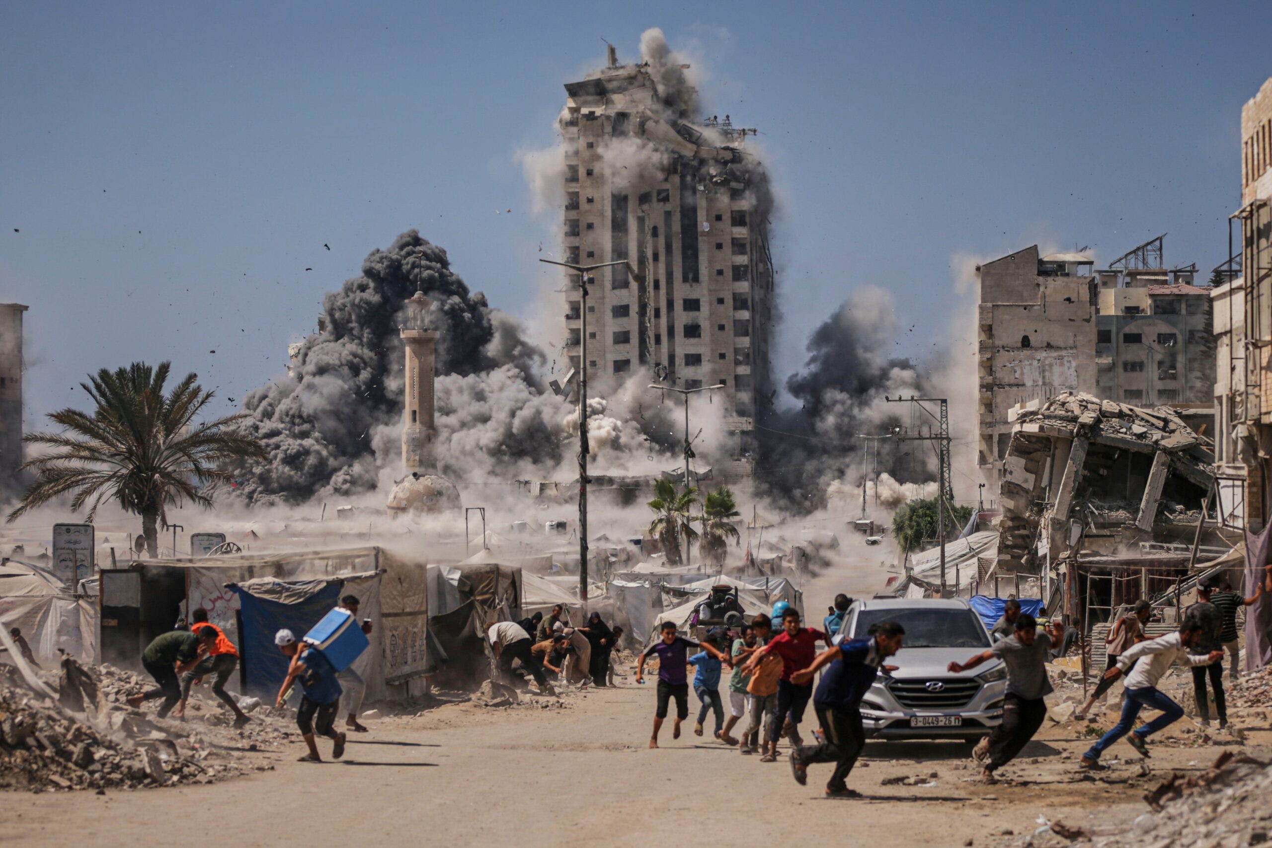 Palestinians run for cover during an Israeli airstrike on a building in Gaza City