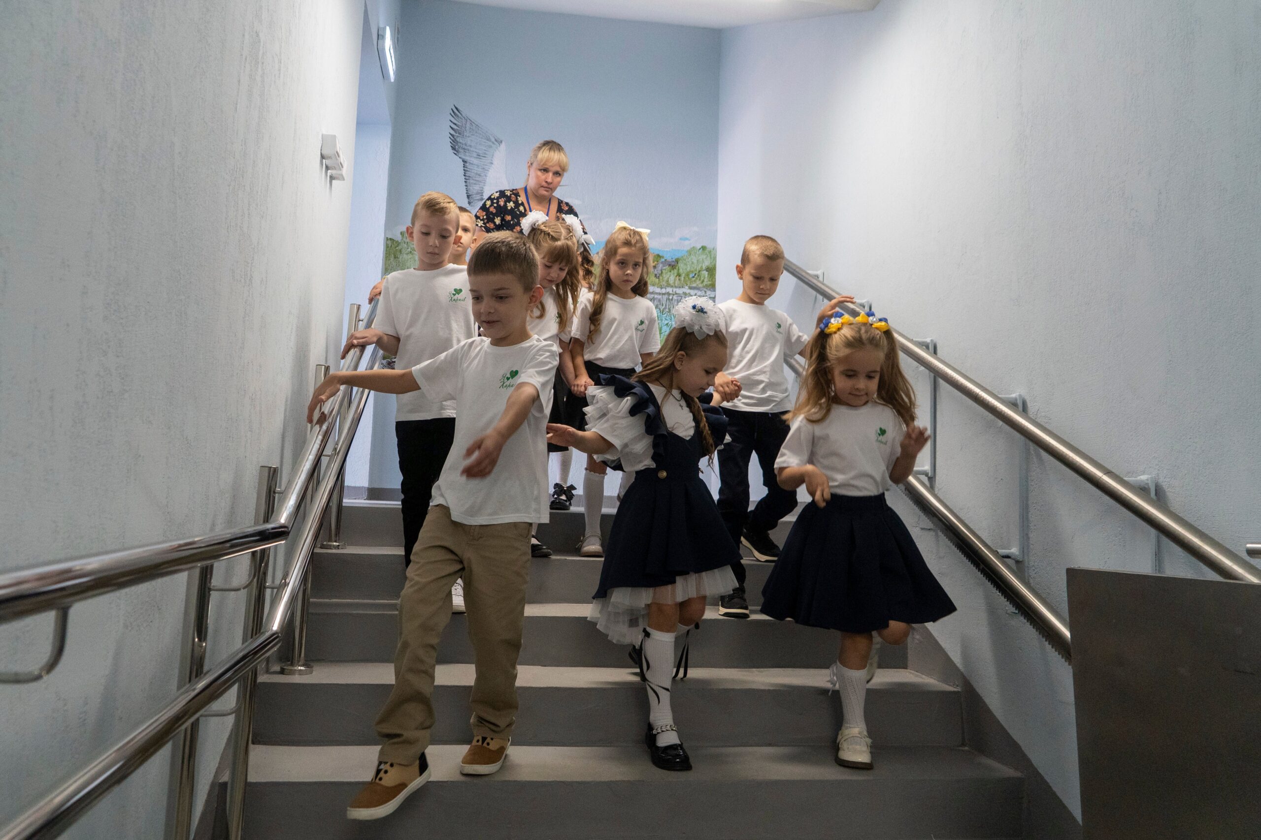 Schoolchildren enter an underground school