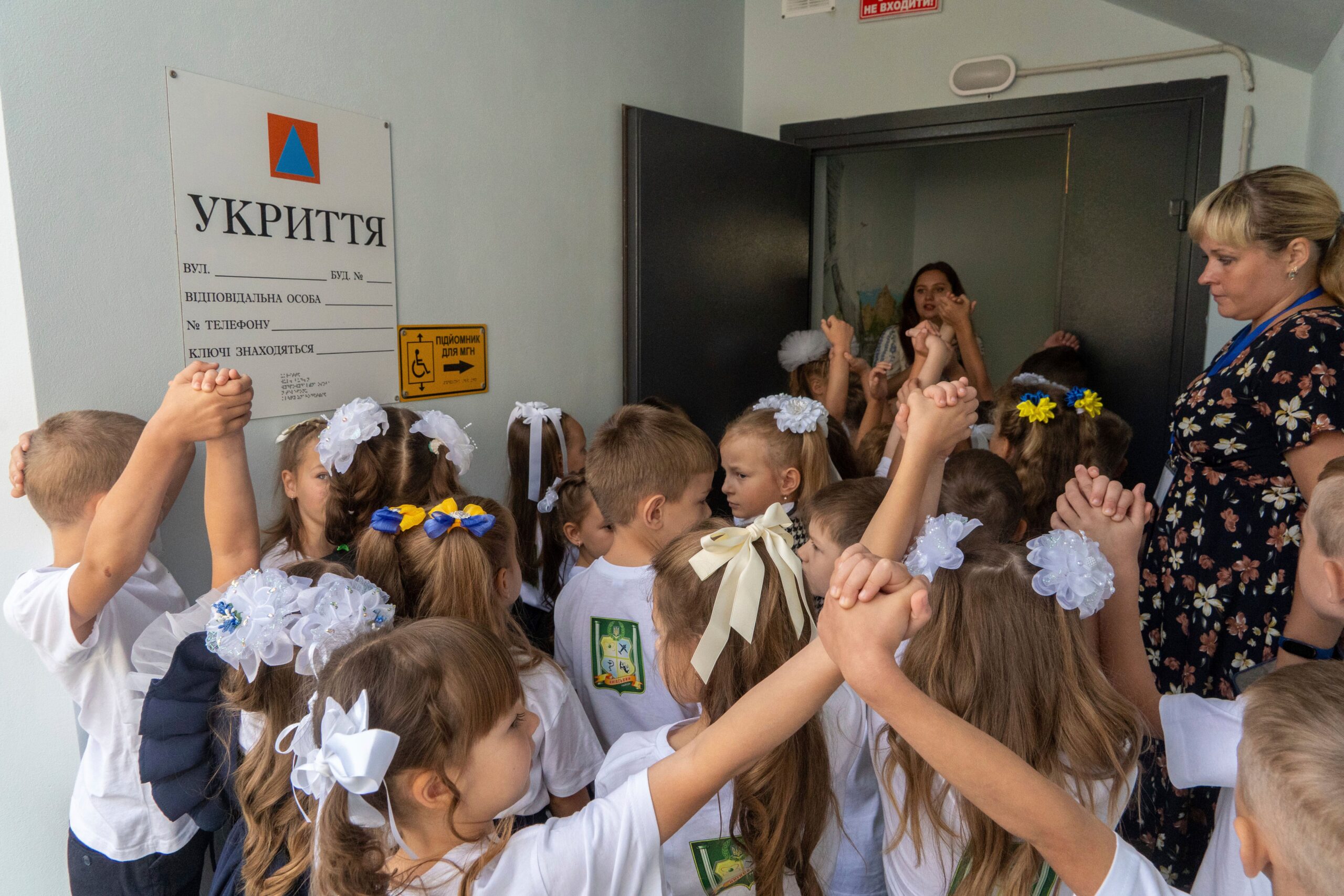 Schoolchildren enter an underground school