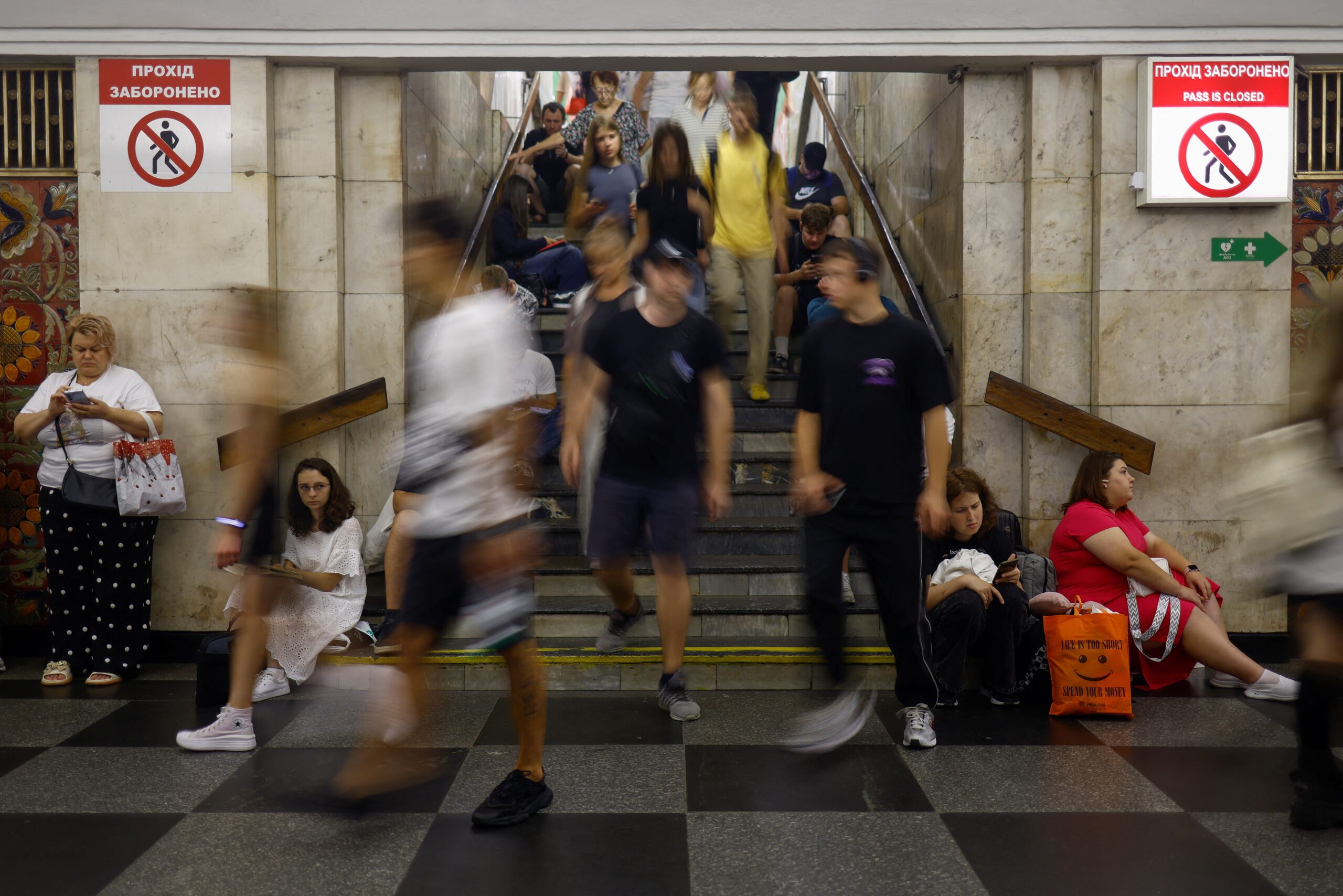 People take shelter inside a metro station while Russian strike drones fly over Kyiv