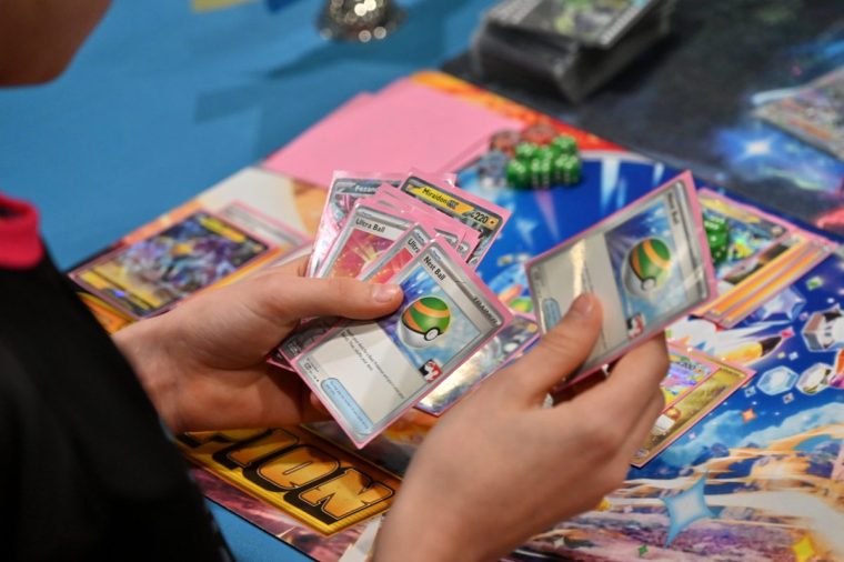 LONDON, ENGLAND - FEBRUARY 21: Competitors hold and deal Pokemon cards as they play during the during the Pok??mon European International Championship 2025 at ExCel London on February 21, 2025 in London, England. Players are playing for Championship Points that will determine who will earn an invitation to the 2025 World Championships in Anaheim, California, in August. (Photo by John Keeble/Getty Images)