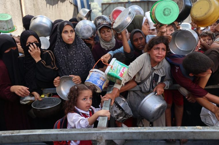 Palestinians queue to receive a hot meal from a charity kitchen in the Nuseirat refugee camp in the Israel-besieged Gaza Strip on September 11, 2025, amid a UN-declared famine after nearly two years of war. (Photo by Eyad BABA / AFP) (Photo by EYAD BABA/AFP via Getty Images)