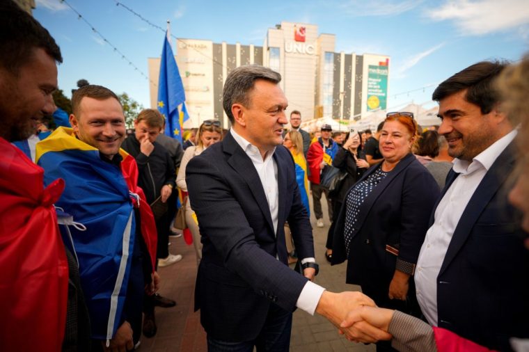 Moldova's Prime Minister Dorin Recean shakes hands with supporters during a pro-EU rally of the ruling Party of Action and Solidarity (PAS), in Chisinau, Moldova, Friday, Sept. 26, 2025, ahead of parliamentary elections taking place on Sept.28. (AP Photo/Vadim Ghirda)