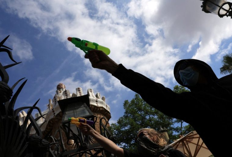 Anti-tourism activists use water pistols during a protest against mass tourism in front of the Park Guell on World Tourism Day in Barcelona, Spain, September 27, 2025. REUTERS/Nacho Doce
