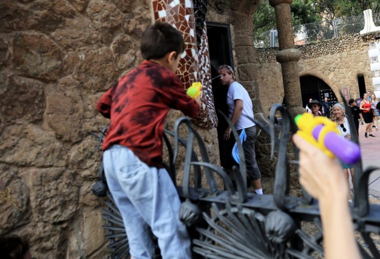 A child and an anti-tourism activist use water pistols during a protest against mass tourism in front of the Park Guell on World Tourism Day in Barcelona, Spain, September 27, 2025. REUTERS/Nacho Doce