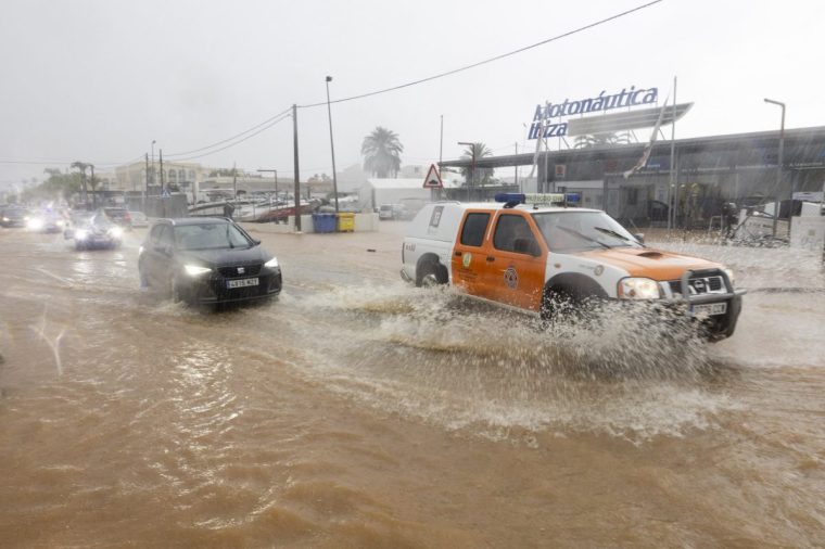 A civil protection vehicle drives through a flooded street in Sant Jordi on the island of Ibiza on September 30, 2025. (Photo by Vicent MARI / AFP) (Photo by VICENT MARI/AFP via Getty Images)