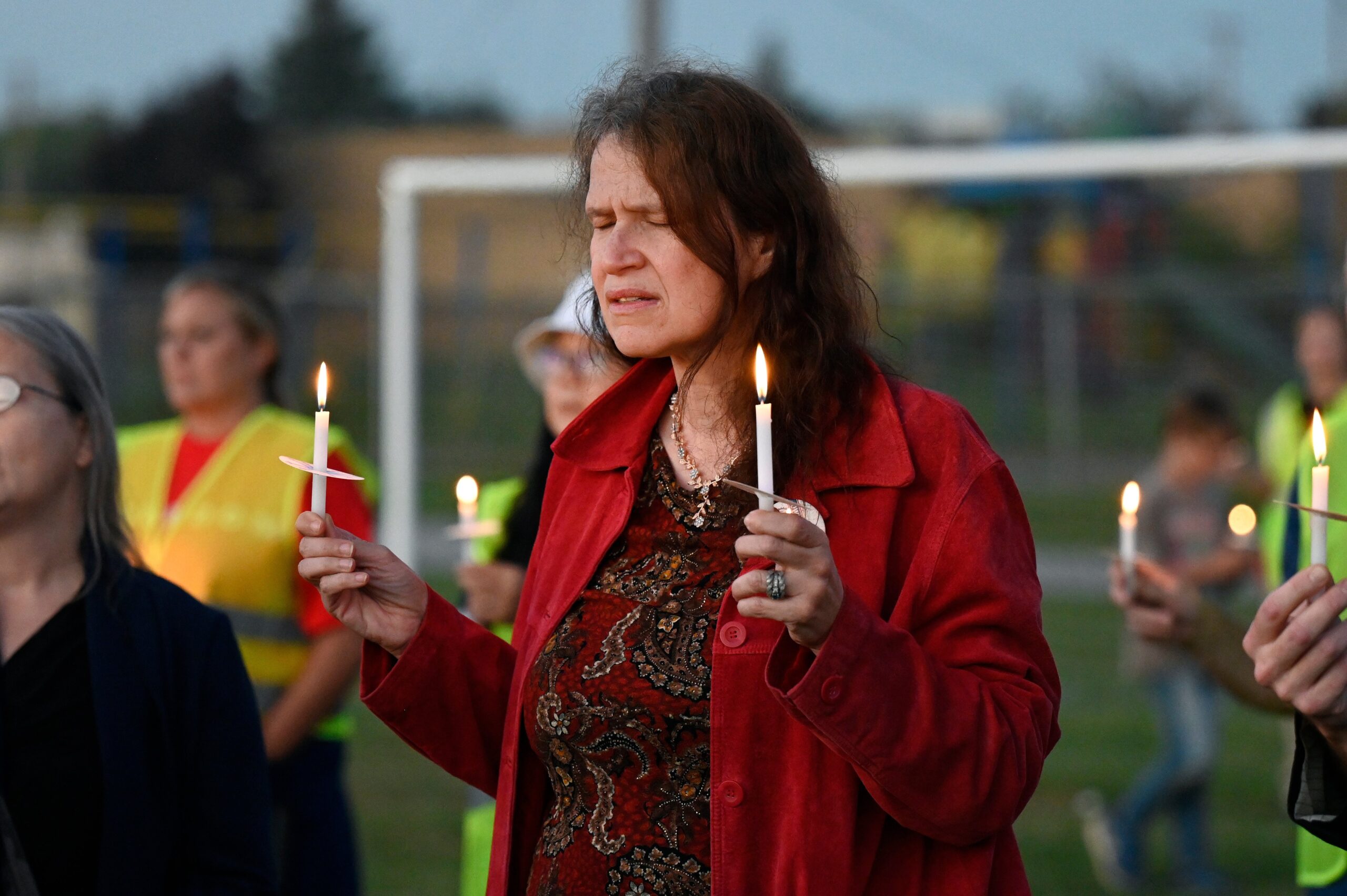 Attendees hold their lit candles during a vigil for a nearby church shooting held at Holy Redeemer Church in Burton, Sunday, 28 September 2025