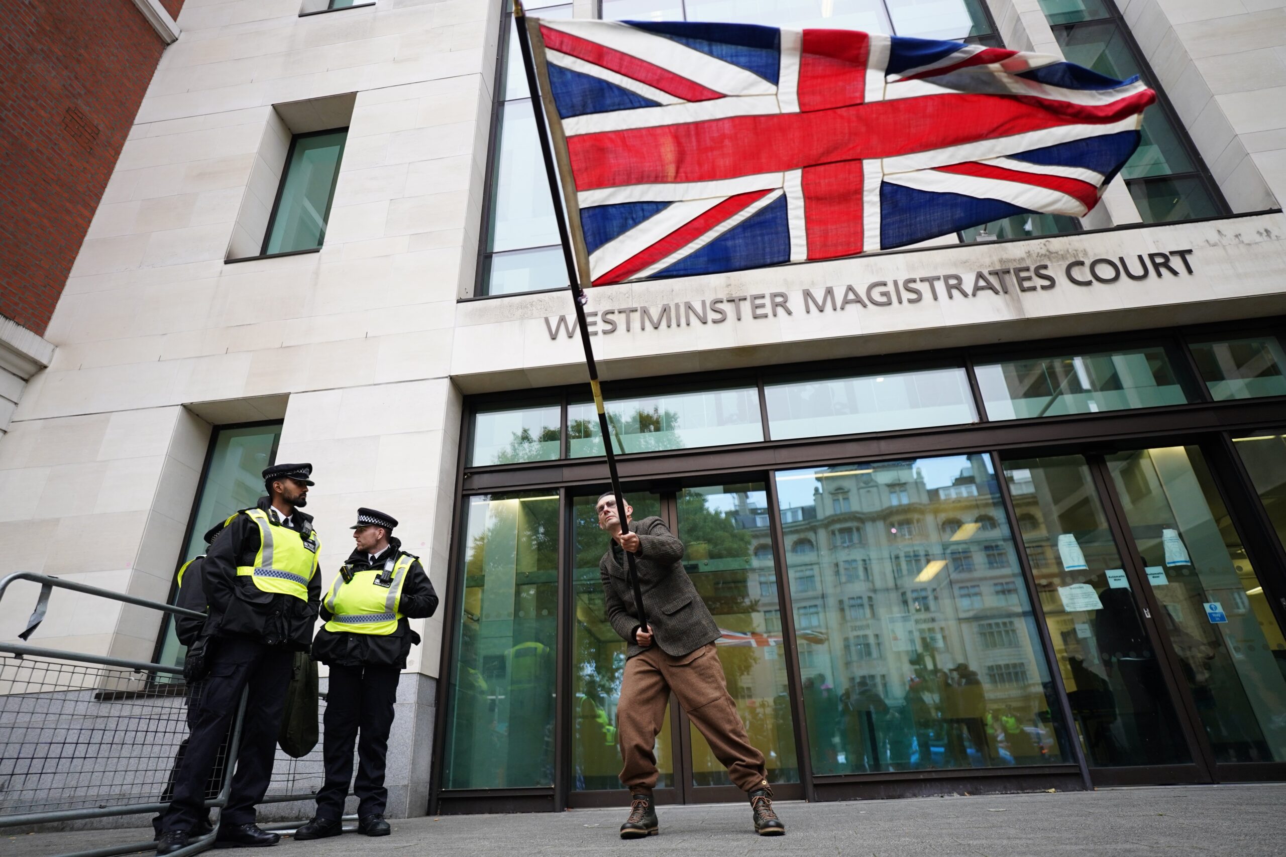A man flies a Union flag outside Westminster Magistrates’ Court (Ben Whitley/PA)