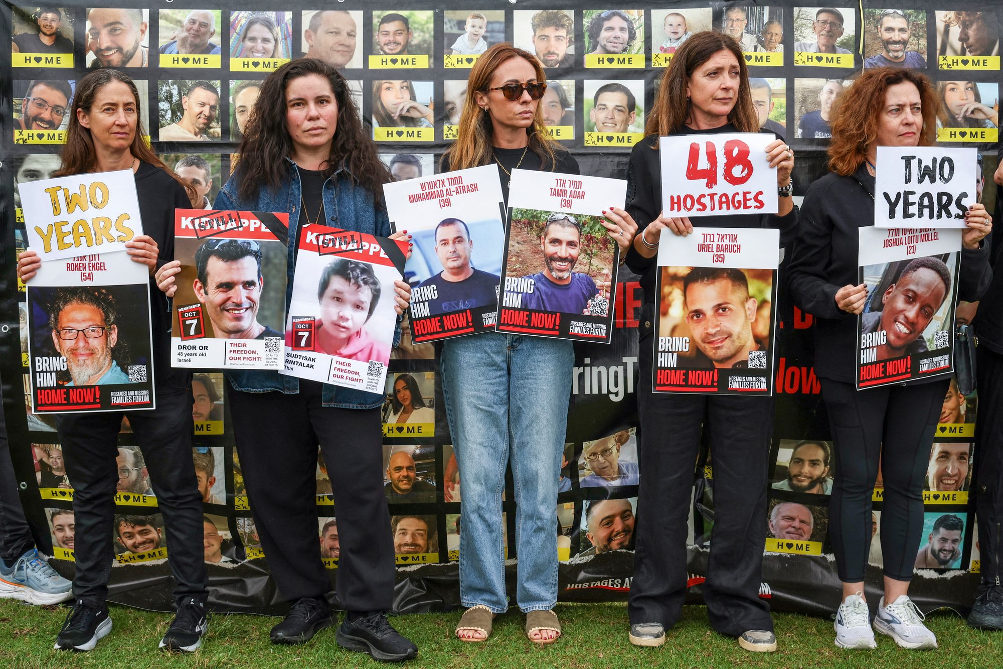 Members of the Australian Jewish community hold a banner and placards bearing the portraits of Israelis held hostage in the Gaza Strip by Palestinian militants during a rally in Sydney on 7 October 2025