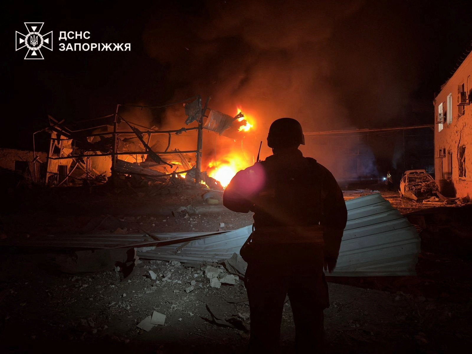 A firefighter looks at a building burning after it was hit during overnight Russian drone and air strikes, amid Russia's attack on Ukraine