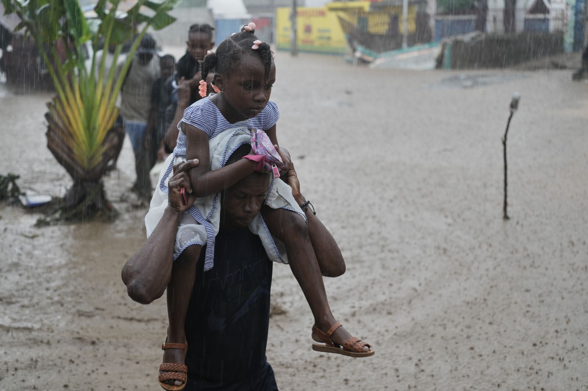 In the stormâs aftermath, residents were seen wading through deep floodwaters while carrying children on their shoulders