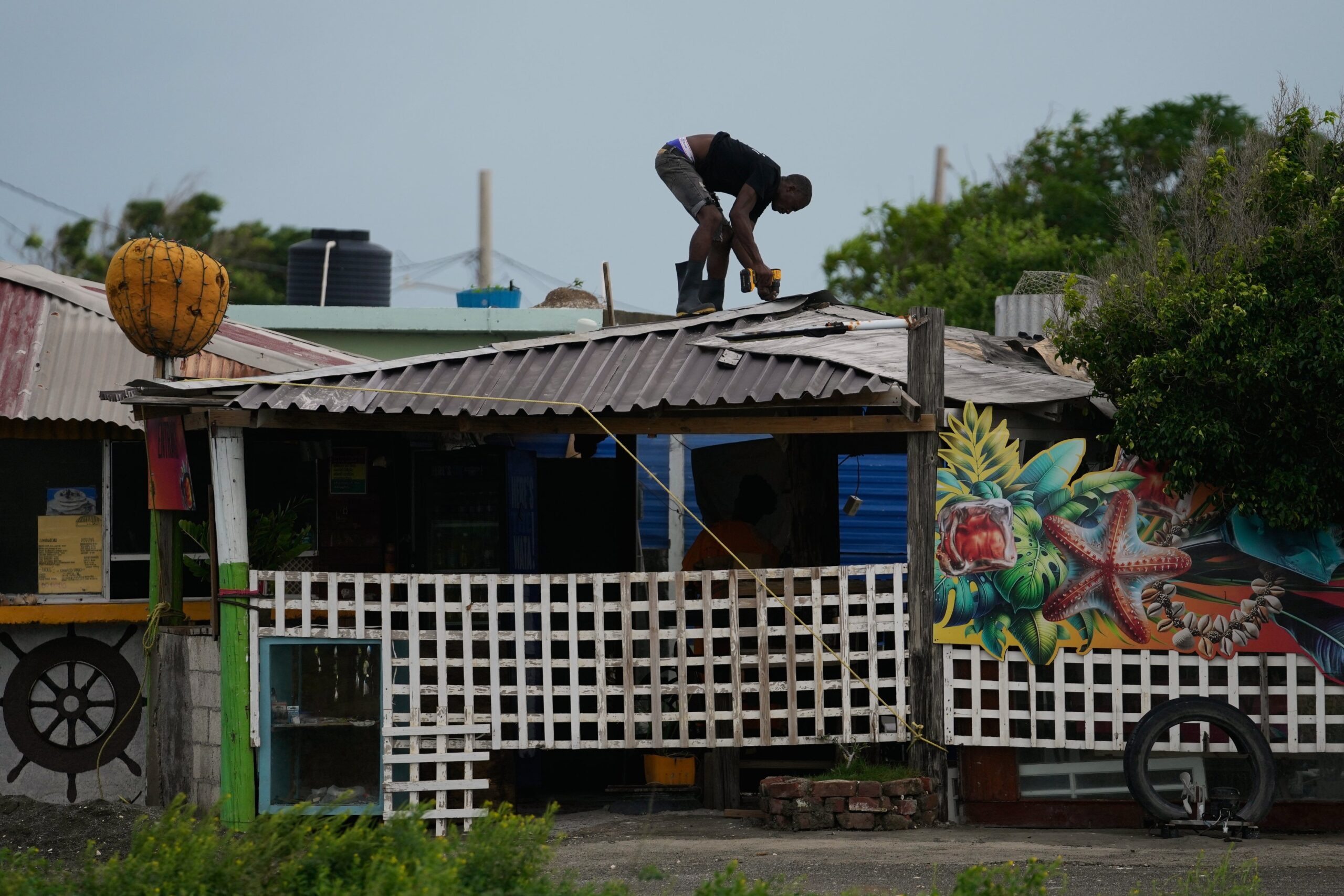 A man fortifies his roof ahead of the storm